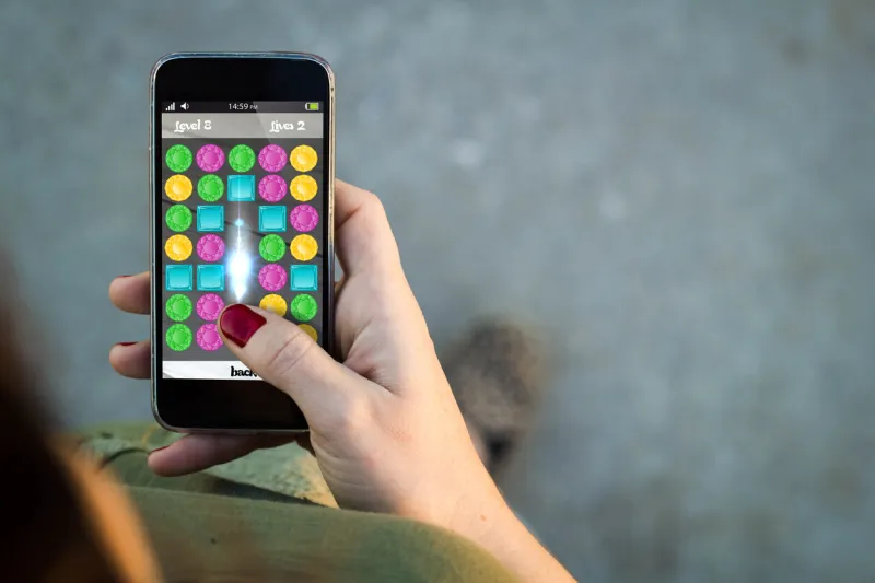 top view of woman walking in the street using her mobile phone with mobile game in the screen with copyspace all screen graphics are made up