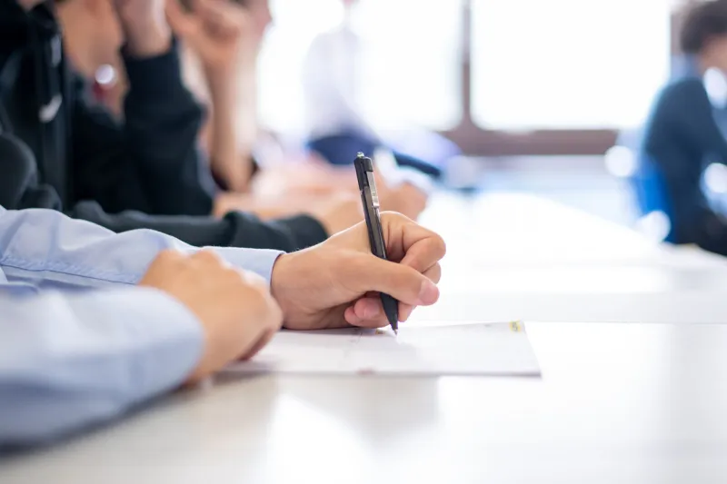 educational setting with student taking notes on paper