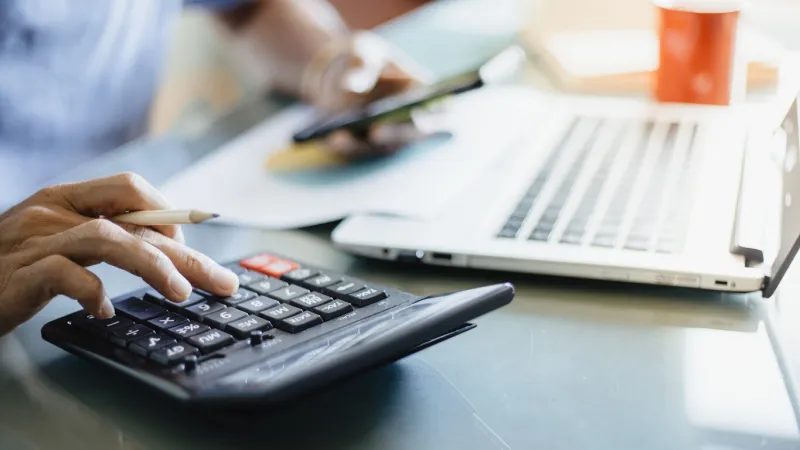 businessman using calculator for analysis maketing plan, accountant calculate financial report, computer with graph chart business, finance and accounting concepts