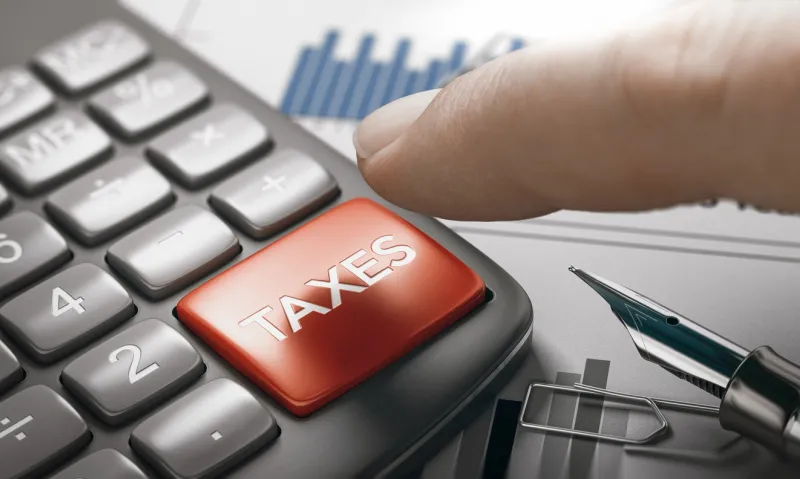 finger about to press a calculator key with the text taxes tax calculation concept composite image between a hand photography and a 3d background