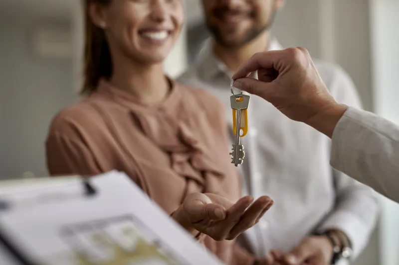 close-up of couple receiving new house keys from real estate agent