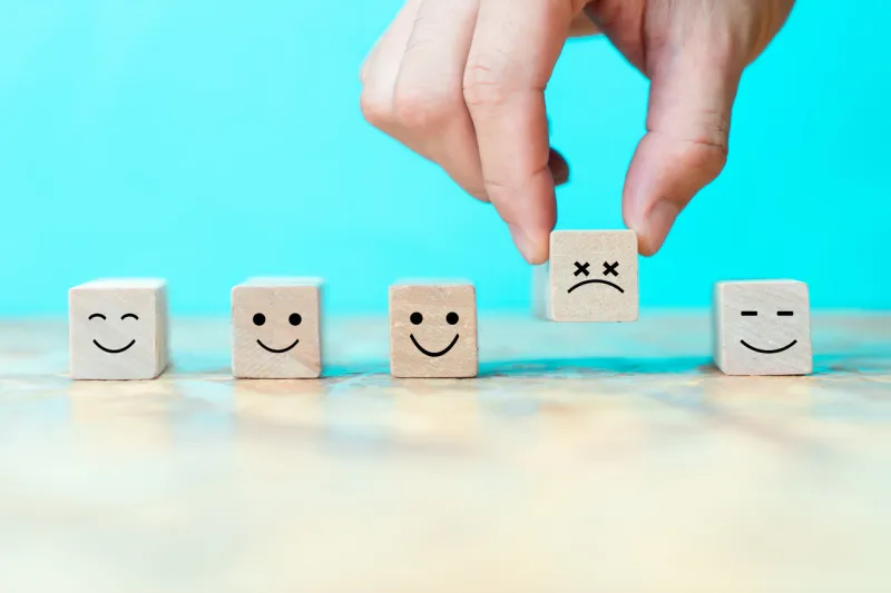 businessman chooses a emoticon icons sadly on wooden block , business bad teamwork concept