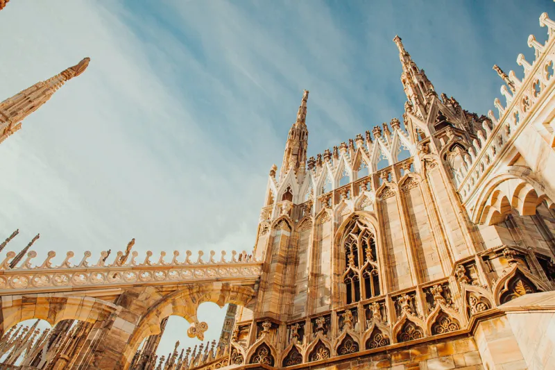roof of milan cathedral duomo di milano with gothic spires and white marble statues top tourist attraction on piazza in milan, lombardia, italy wide angle view of old gothic architecture and art