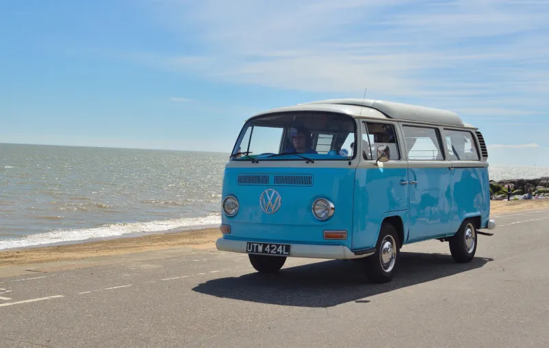 felixstowe, suffolk, england - may 01, 2016  classic blue and white volkswagen camper van being driven along felixstowe seafront promenade