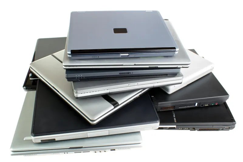 stack of used laptop computers, isolated on white