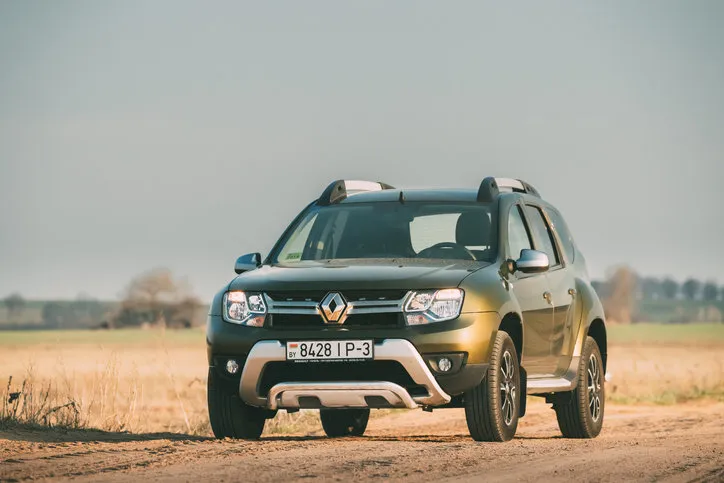 gomel, belarus - april 10, 2019  green car renault duster or dacia duster suv parked on field country road