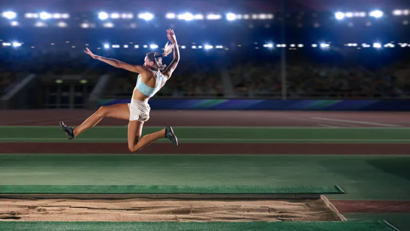long jump championship  professional female athlete jumping on long distance determination, motivation, inspiration of a successful sports woman setting new record result competition on big stadium