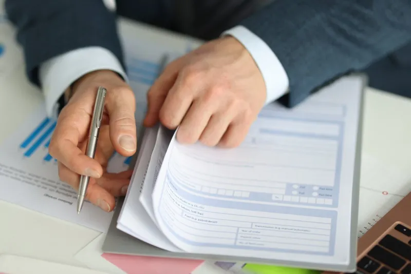 businessman holds pen and stretches application form signing insurance documents concept