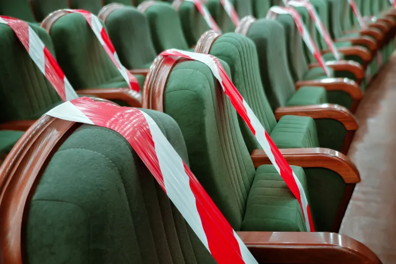 background of empty seats in the cinema, theater, auditorium with a warning label presentation of a conference, opera, theatrical performance work during coronavirus, adhering to social distancing