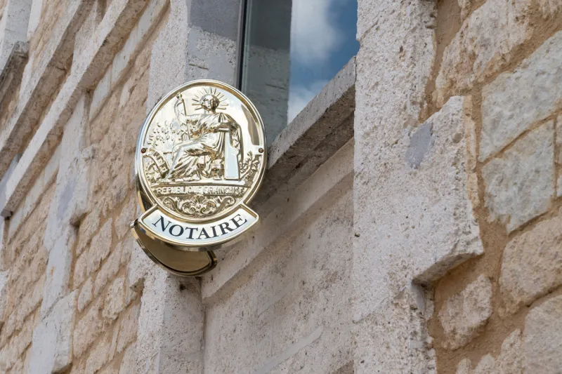 french notaire sign on wall above entrance to the notary office