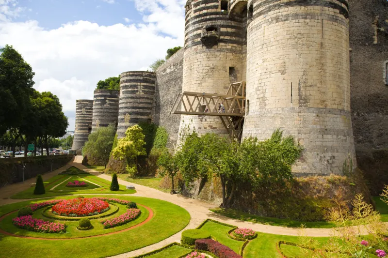 angers, france - july 23, 2009  panoramic of angers chateau and garden in a summer day some people are looking from the gateway