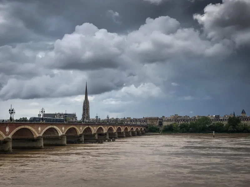 scenic view of bordeaux river bridge with st michel cathedral and storm sky, bordeaux, france high quality photo