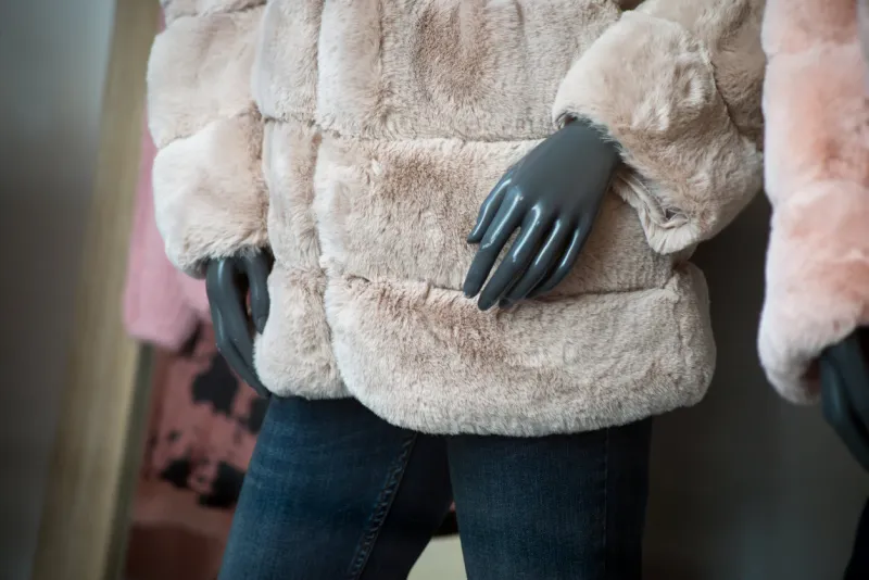 closeup of synthetic fur coat on mannequin in a fashion store showroom