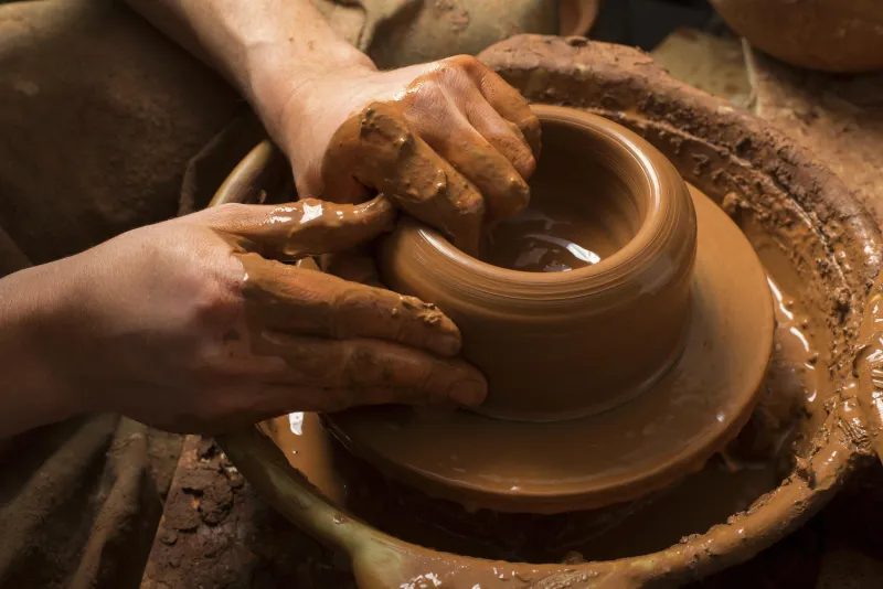mains d'un potier, créant un pot en terre