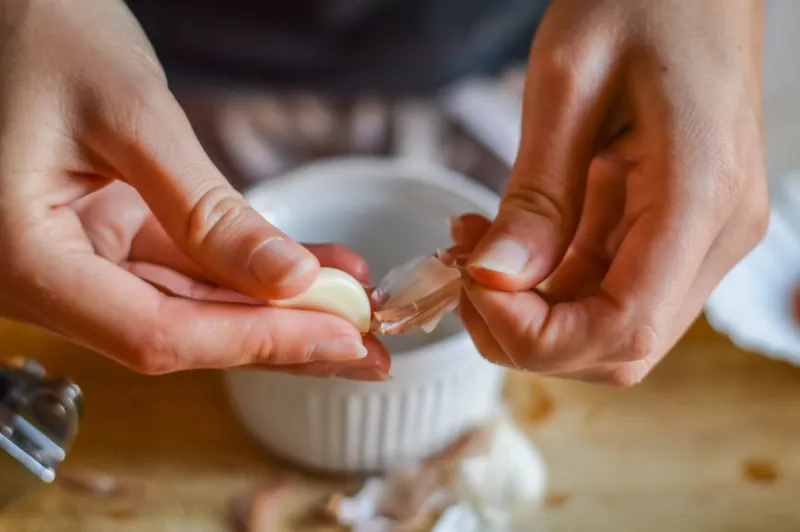 peeling garlic to make a cooking sauce - close up