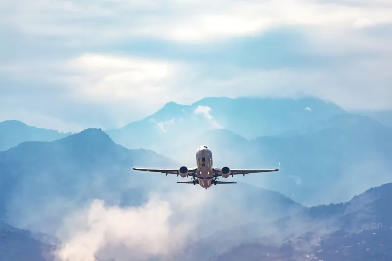 jet flight travel concept stock photo airplane fly above amazing blue misty mountains