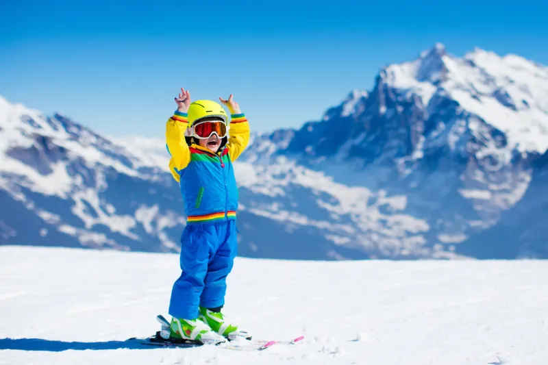 child skiing in mountains active toddler kid with safety helmet, goggles and poles ski race for young children winter sport for family kids ski lesson in alpine school little skier racing in snow