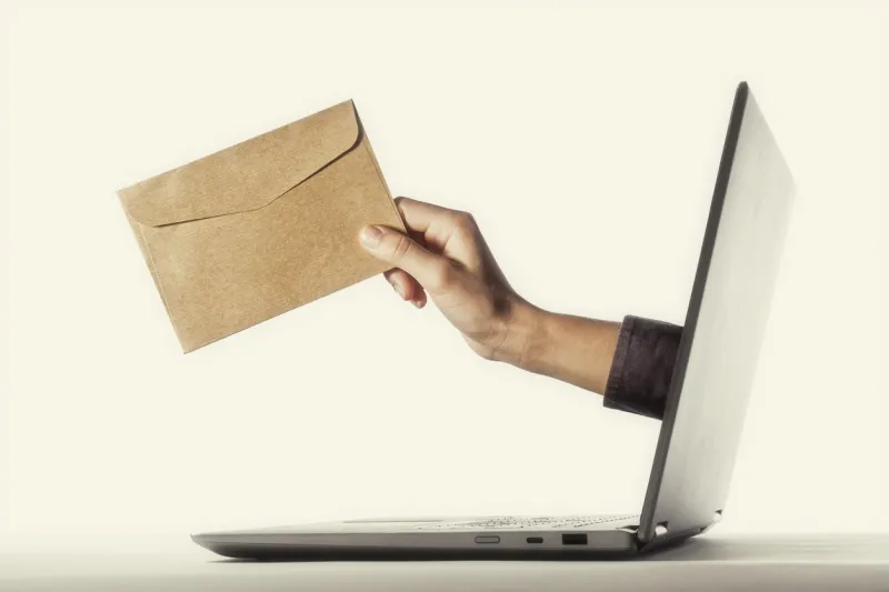 the human hand with envelope stick out of a laptop screen concept of correspondence, feedback, advertising via internet