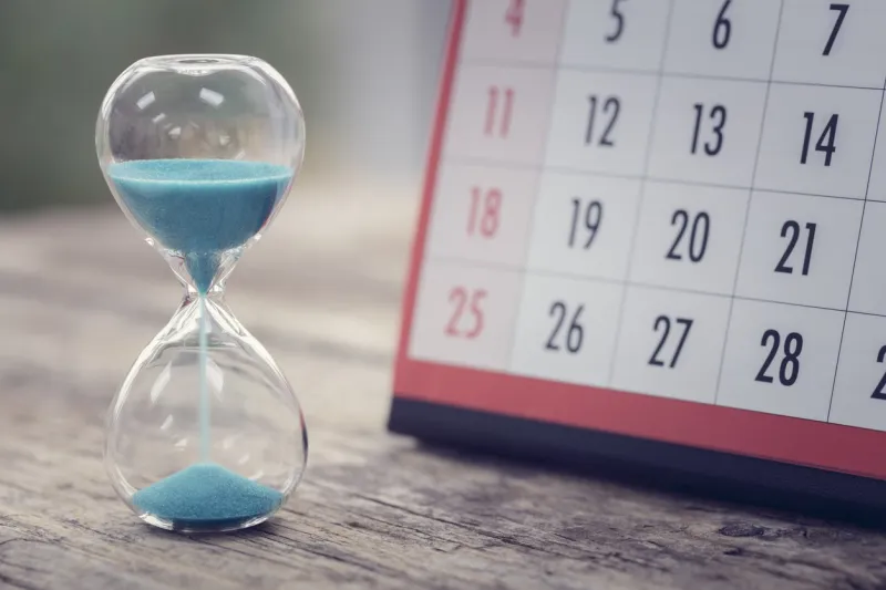 hour glass and calendar concept for time slipping away for important appointment date, schedule and deadline