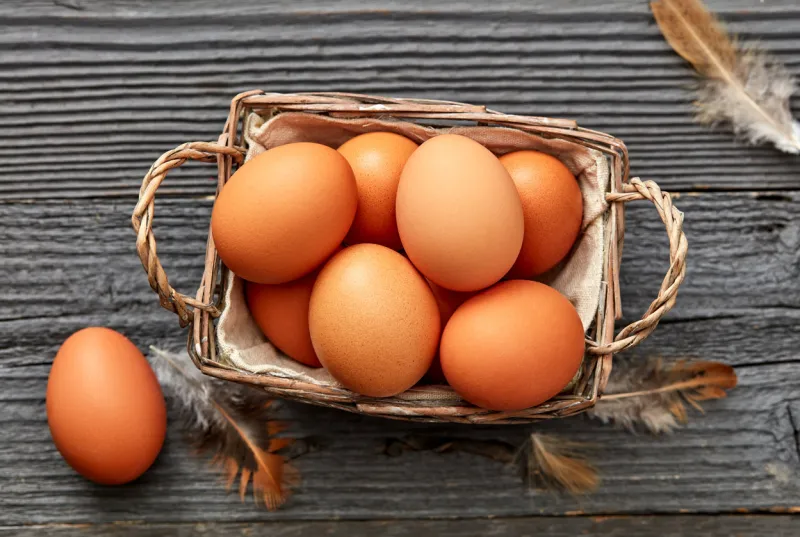 fresh chicken eggs in basket on a rustic background