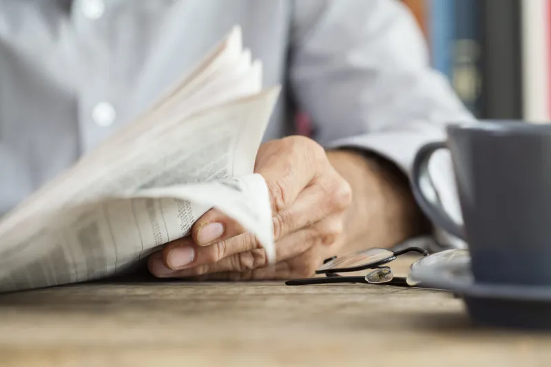 man newspaper reading on table
