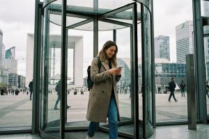 une jeune femme entre dans une tour de la Défense