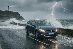 Une photo montrant une voiture sur une route battue par la pluie et la tempête en bord de mer.

Modi