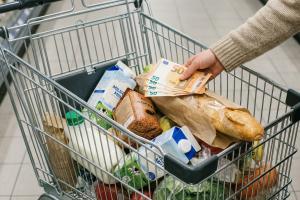 Un plan moyen, filmé en perspective en légère plongée, d'un caddie de supermarché moderne et chromé,