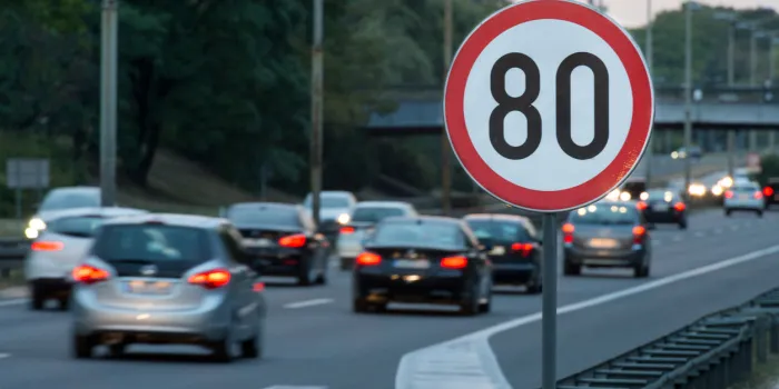 speed limit sign with a traffic in the background