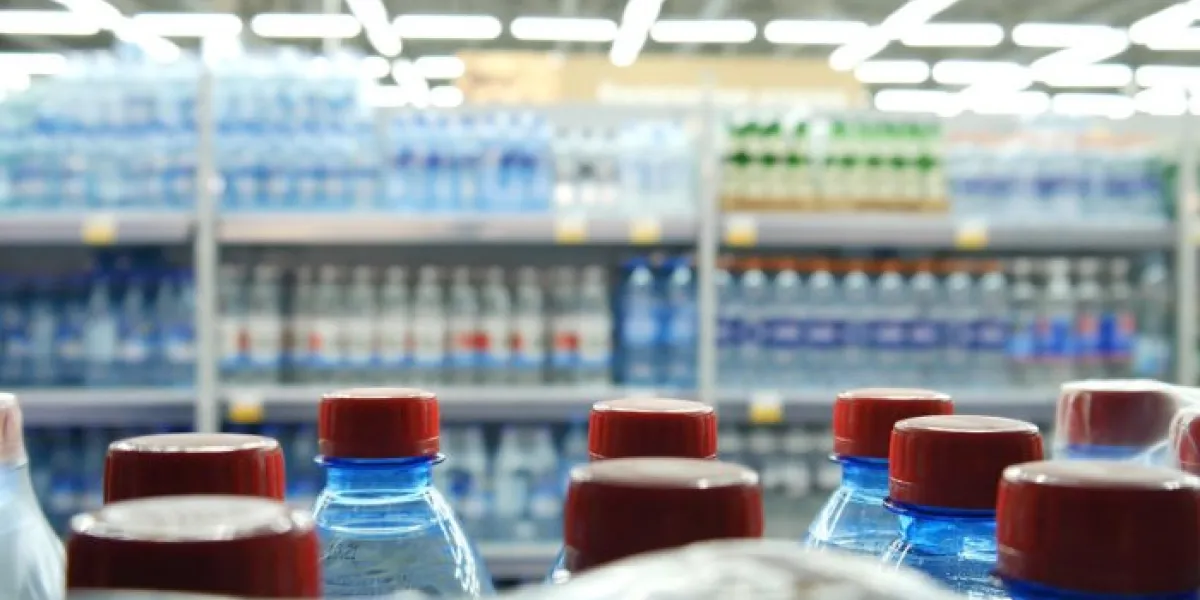 close-up of many bottles of water with red caps on a store shelf