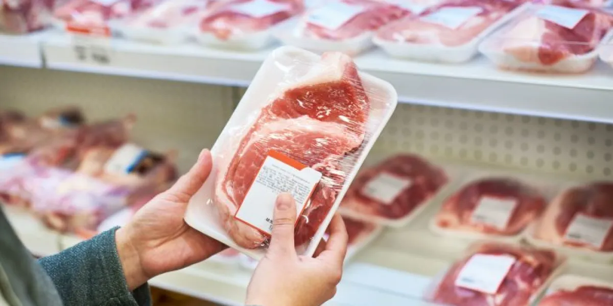 buyer hands with pork meat packages at the grocery store