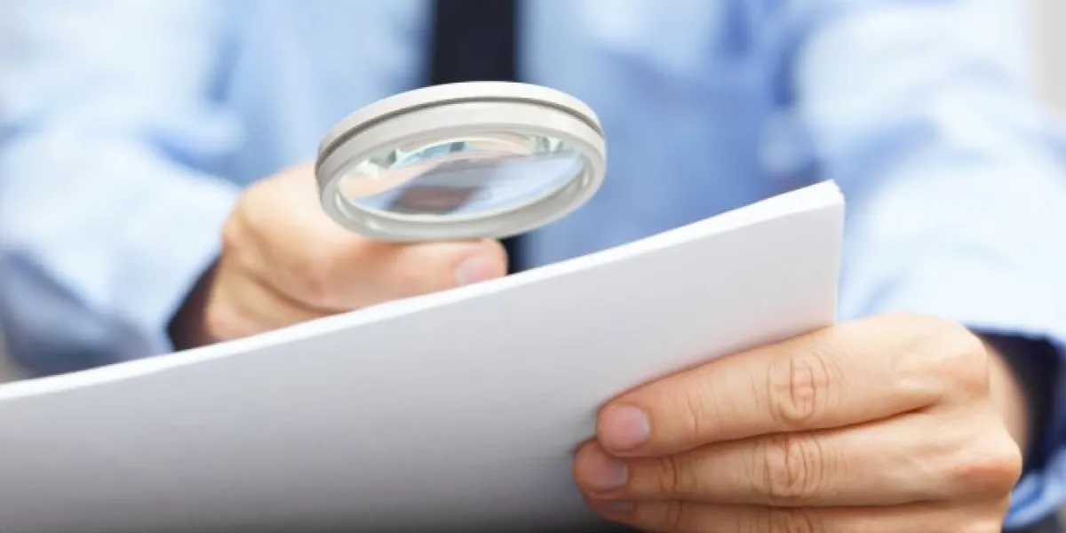 businessman looking through a magnifying glass to contract