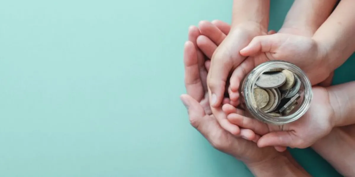 child and parent hands holding money jar, donation, saving, family finance plan concept