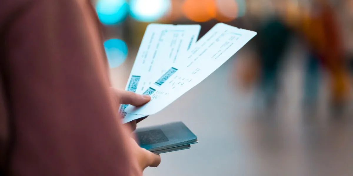 a young girl is going on a trip, holds plane tickets in her hands and goes to check-in, boarding a flight, close-up view of a boarding pass on a blurred background