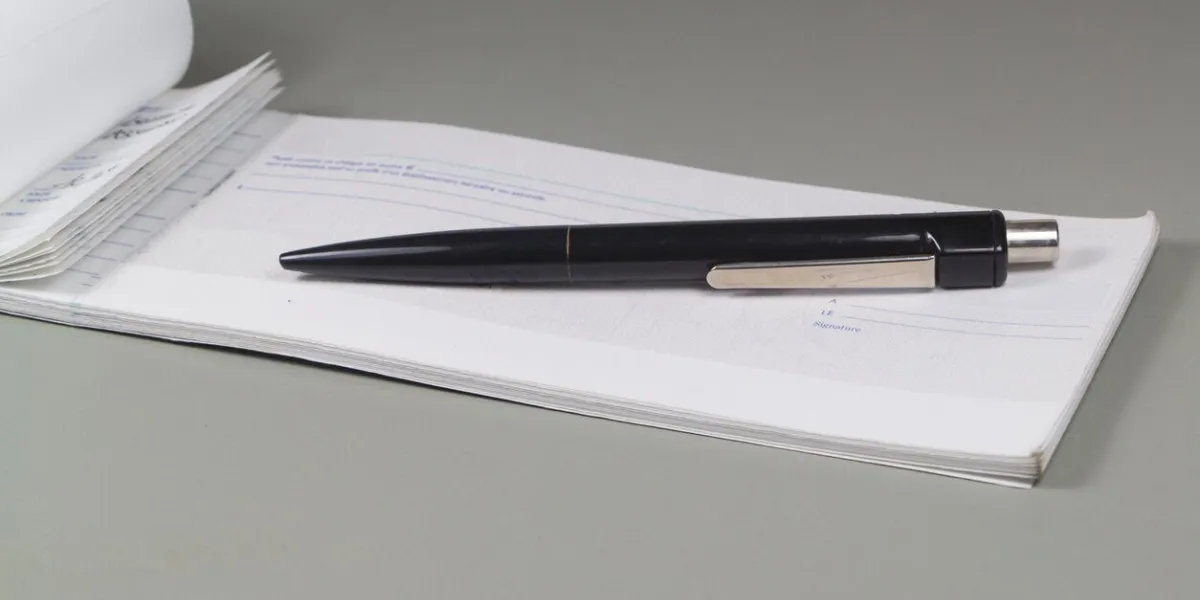 french checkbook and black pen on a desk