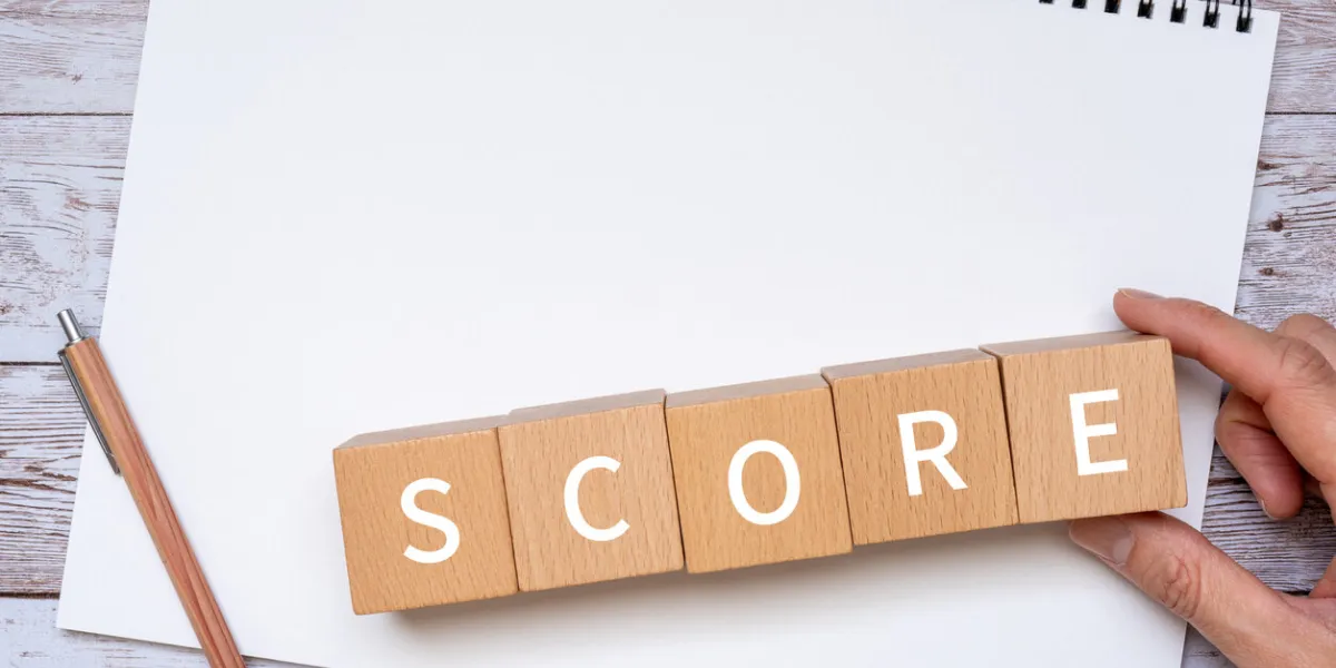 wooden blocks with score text of concept, a pen, a notebook, and a hand