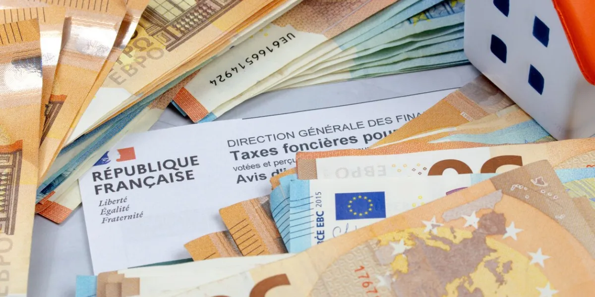 french property tax sheet and pile of euro banknotes close-up