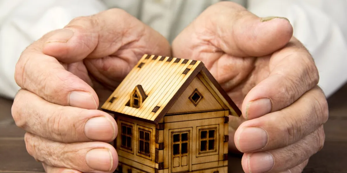 old man protecting house model with hands risk insurance the concept of mortgages and bank loans poverty rental property