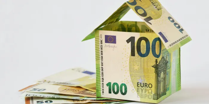 house made of euro banknotes on white background - concept of building bonus, real estate investment, mortgage and home insurance
