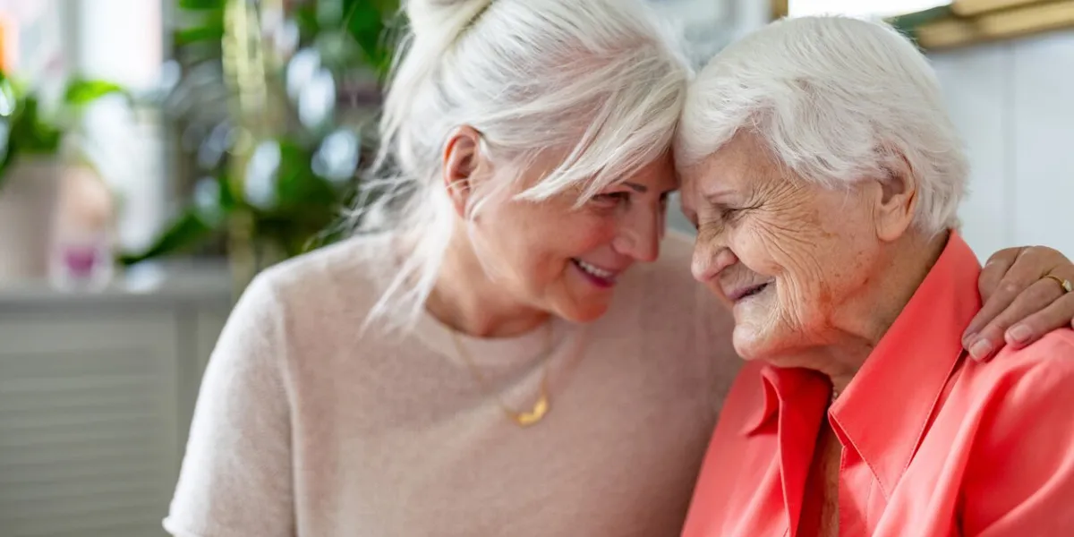 happy senior woman with her adult daughter at home