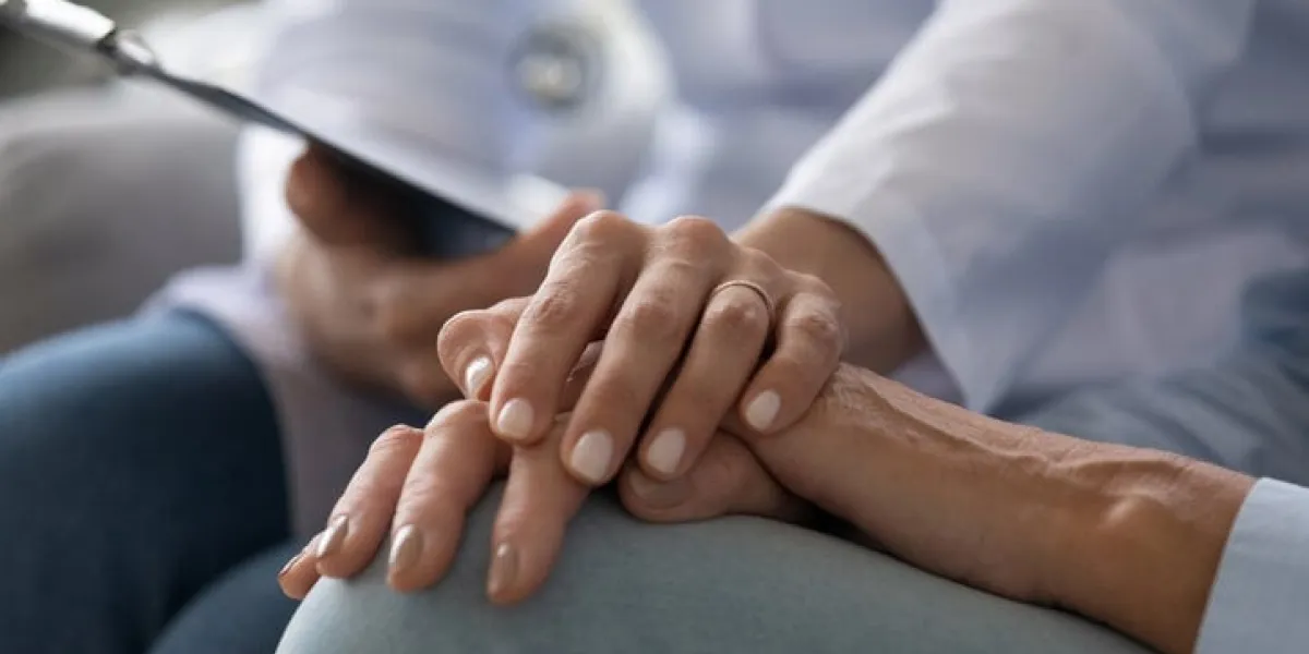 young woman doctor nurse wear white medical uniform holding hand of senior old female grandmother patient having disease health problem give support help empathy and comfort concept, close up view