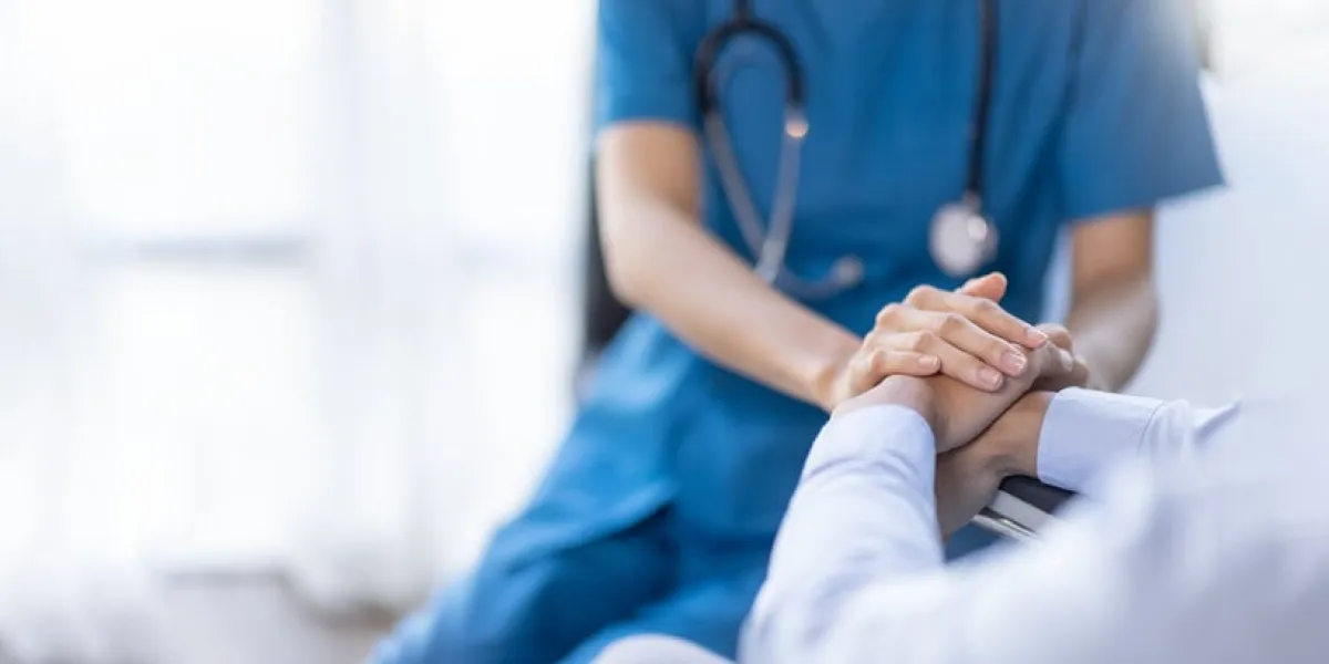 cropped shot of a female nurse hold her senior patient's hand giving support doctor helping old patient with alzheimer's disease female carer holding hands of senior man