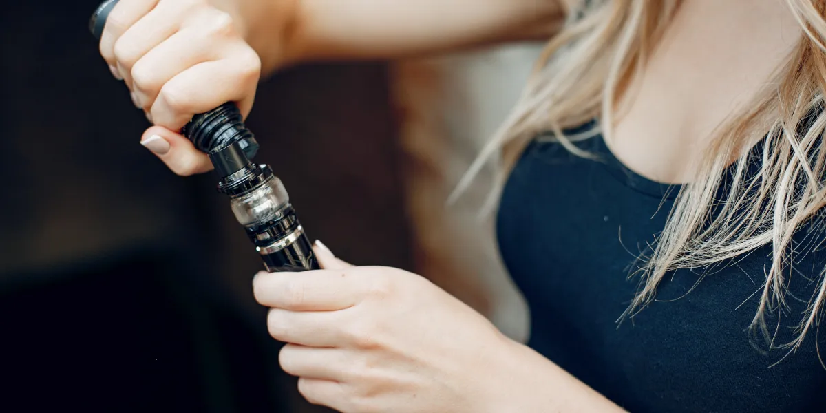 Élégante jeune fille dans une ville avec vape