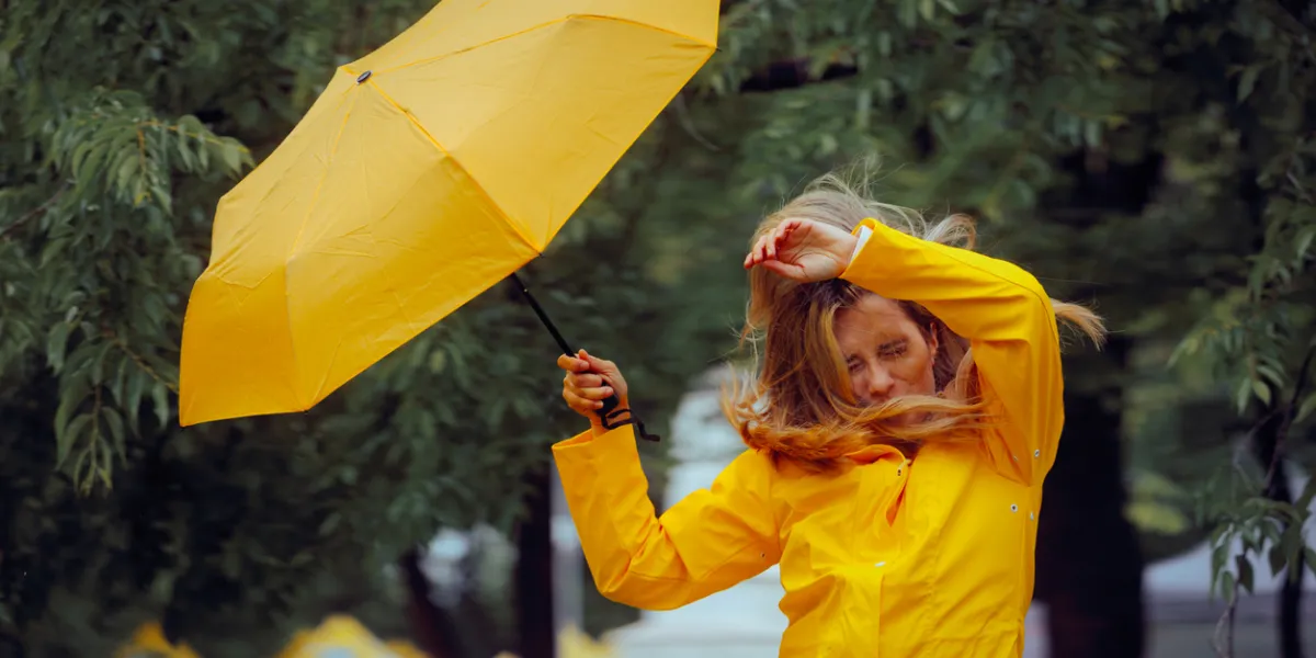 Femme inconfortable à cause du vent pendant une tempête de pluie