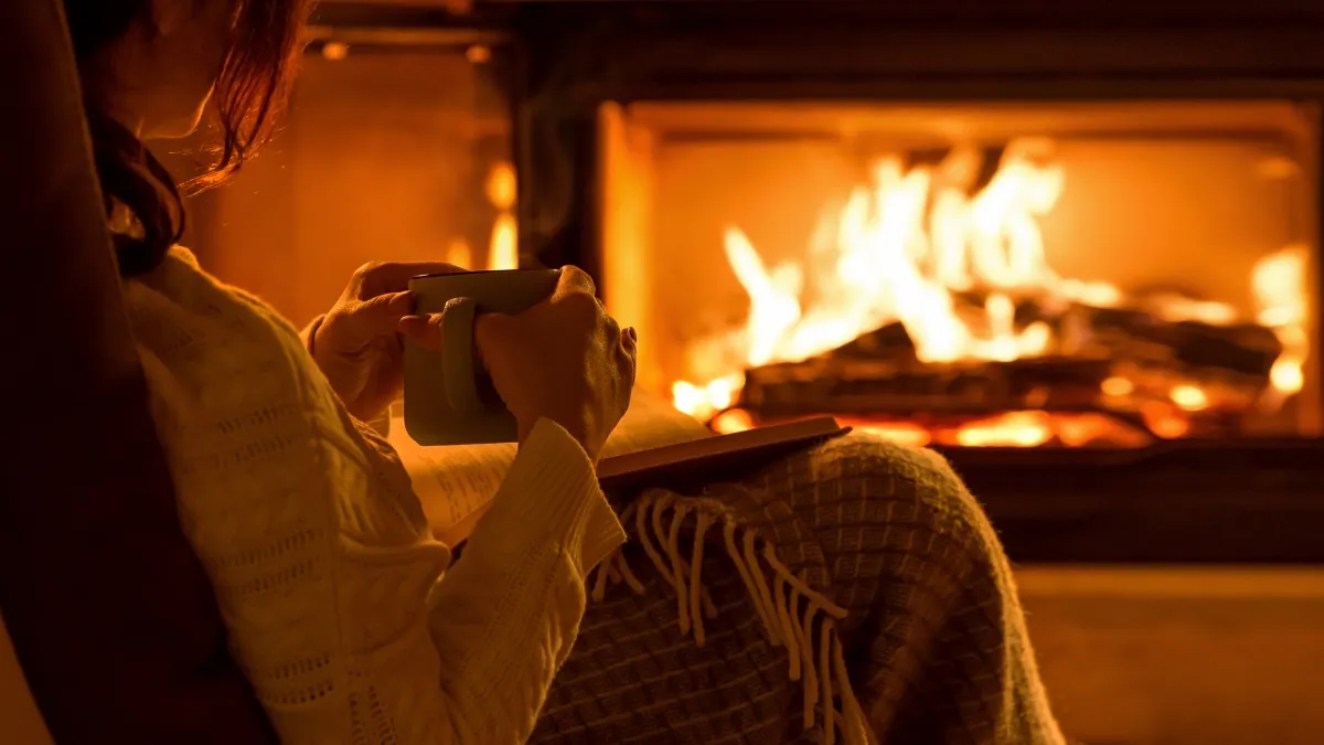 femme au coin d'un feu de cheminée