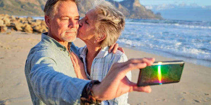 selfie, kiss and senior couple at the beach for a vacation memory in retirement in argentina affection, love and elderly man and woman taking a photo at the ocean during a date on valentines day