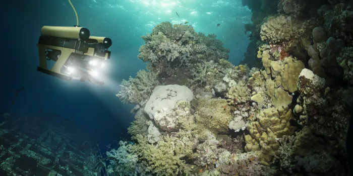 robot inspects a sunken ship deep under water