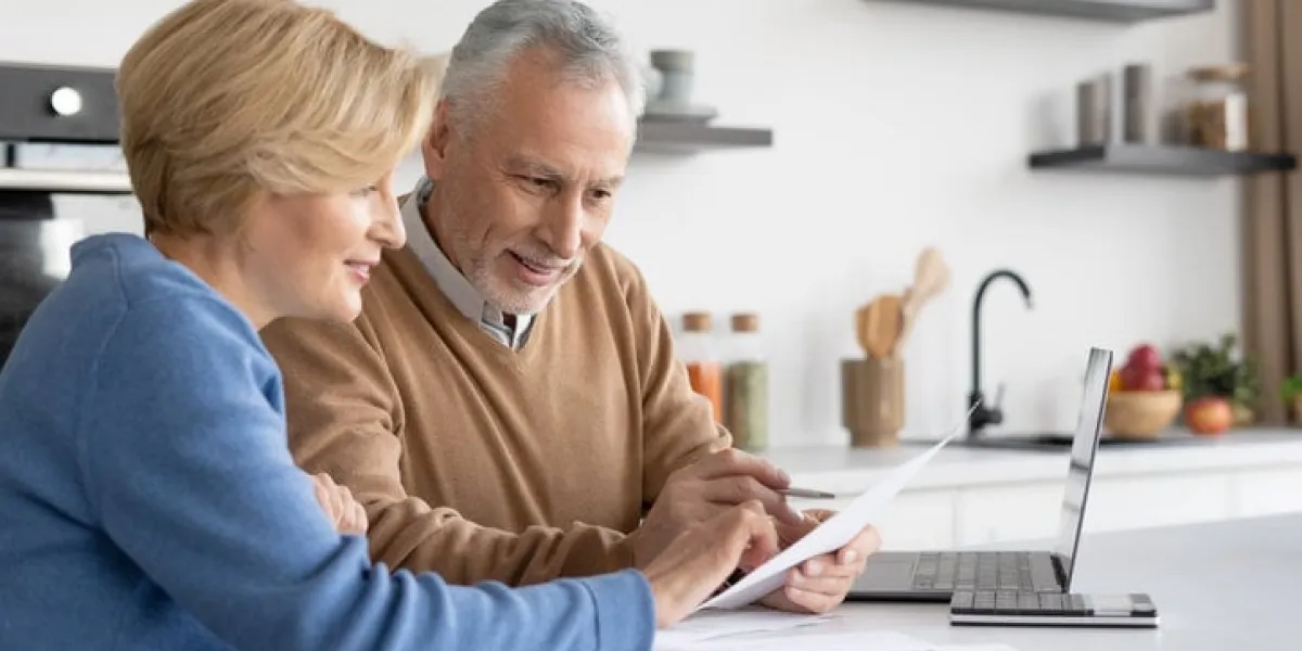 smiling mature family check utility bills for water supply, gas and electricity, paying online together couple filling in quarterly and annual tax forms, calculation of pension savings