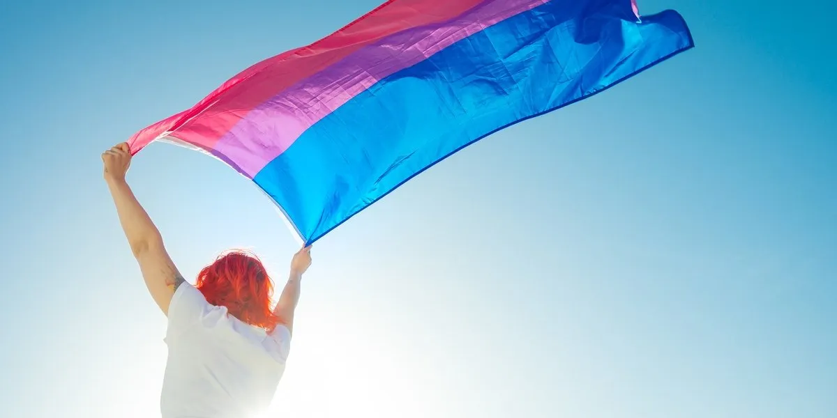 a beautiful low angle shot of a female waving red and blue flag