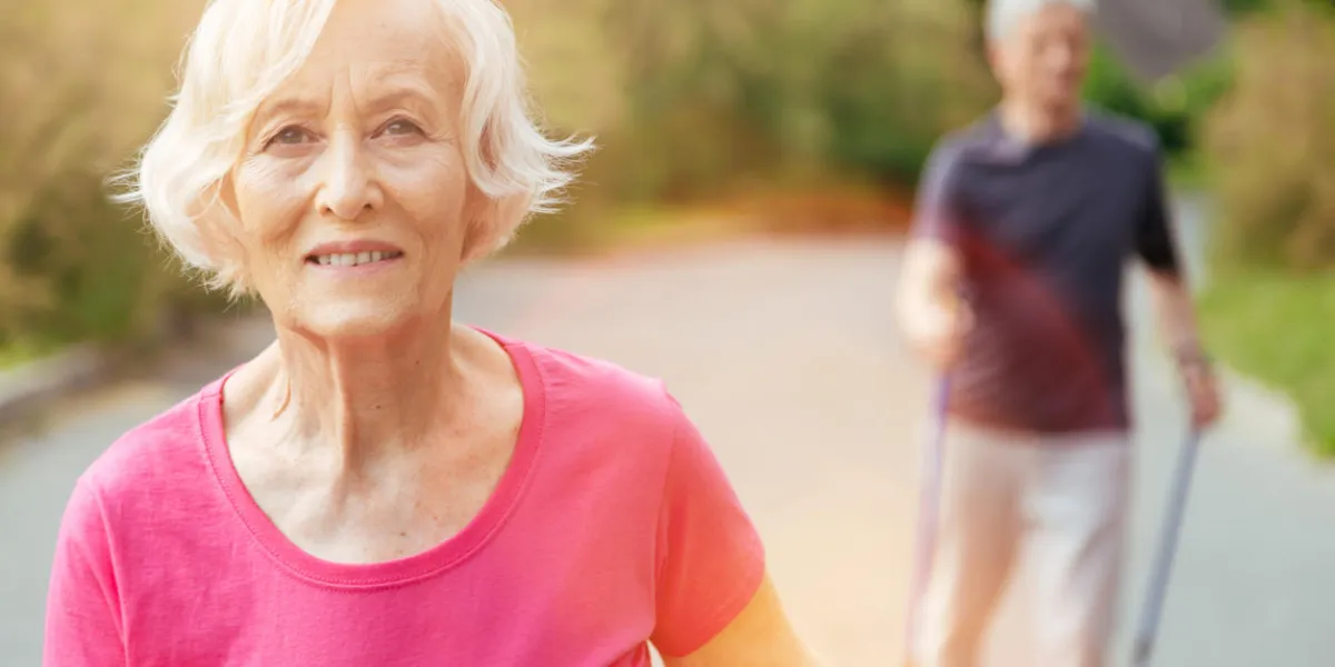 cheerful smile happy nice senior woman looking at you and smiling while walking in the park